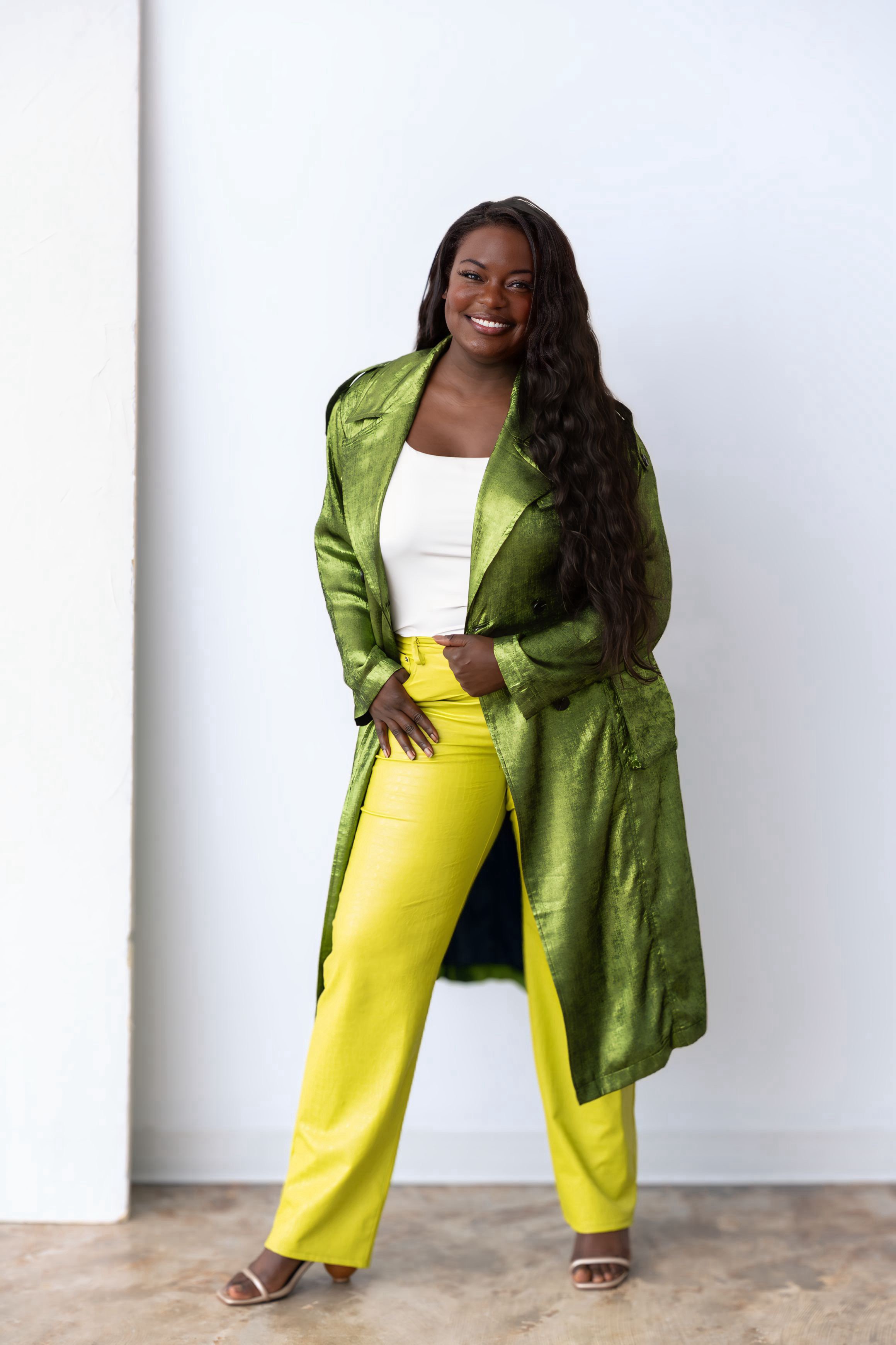 Dr. Raven Baxter in a green coat, full-length studio portrait